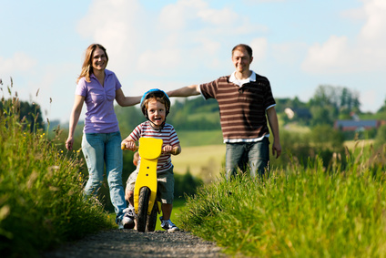 Familie zu Fuß und mit Fahrrad im Sommer © Kzenon - Fotolia.com